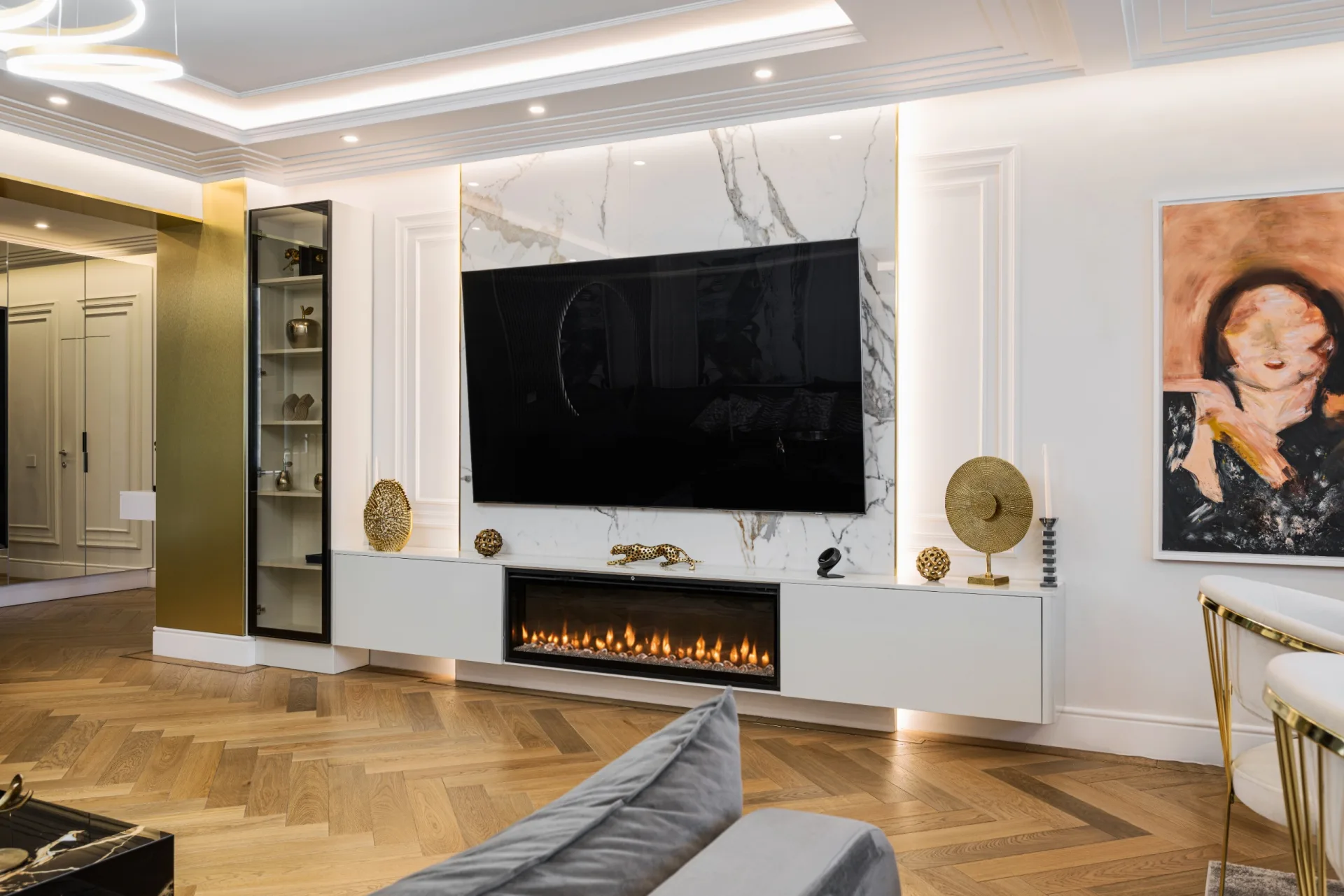Living room in Penthouse Verzișori with a white marble TV wall, built-in fireplace and herringbone oak floor
