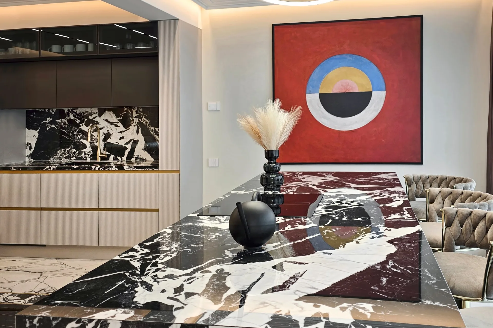 Kitchen in South Garden Penthouse with a black and white marble island and a large red abstract painting